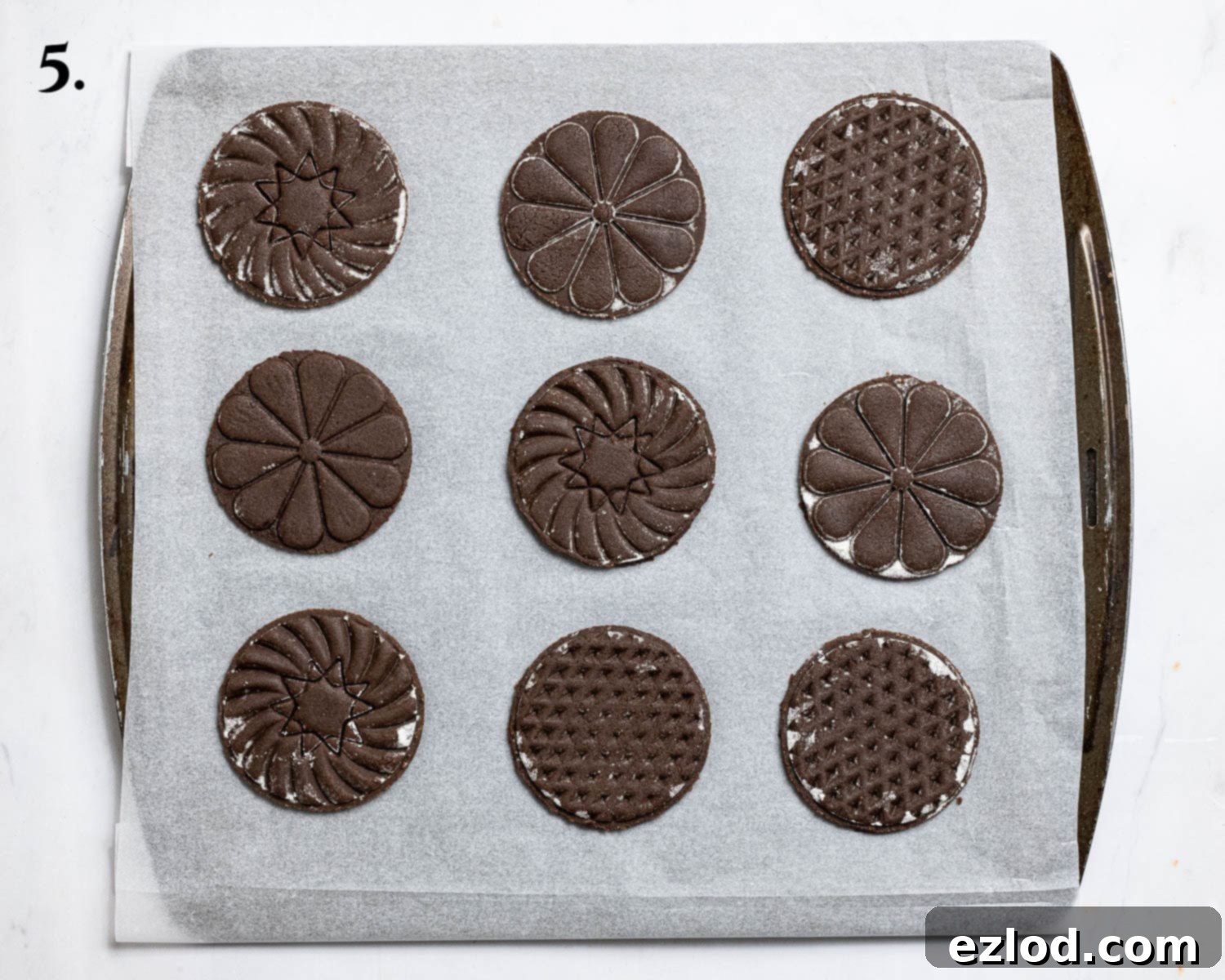 Step 5: The meticulously cut-out stamped cookies arranged on a baking tray, ready for baking.