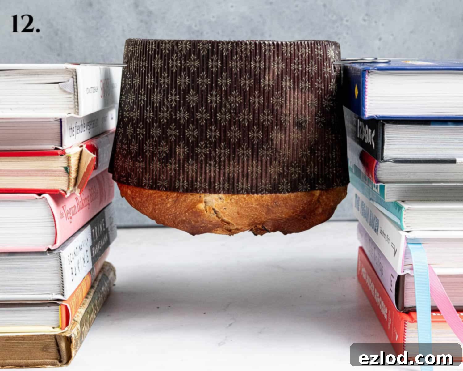 Step 12, the skewered panettone hung upside-down between two stacks of books.