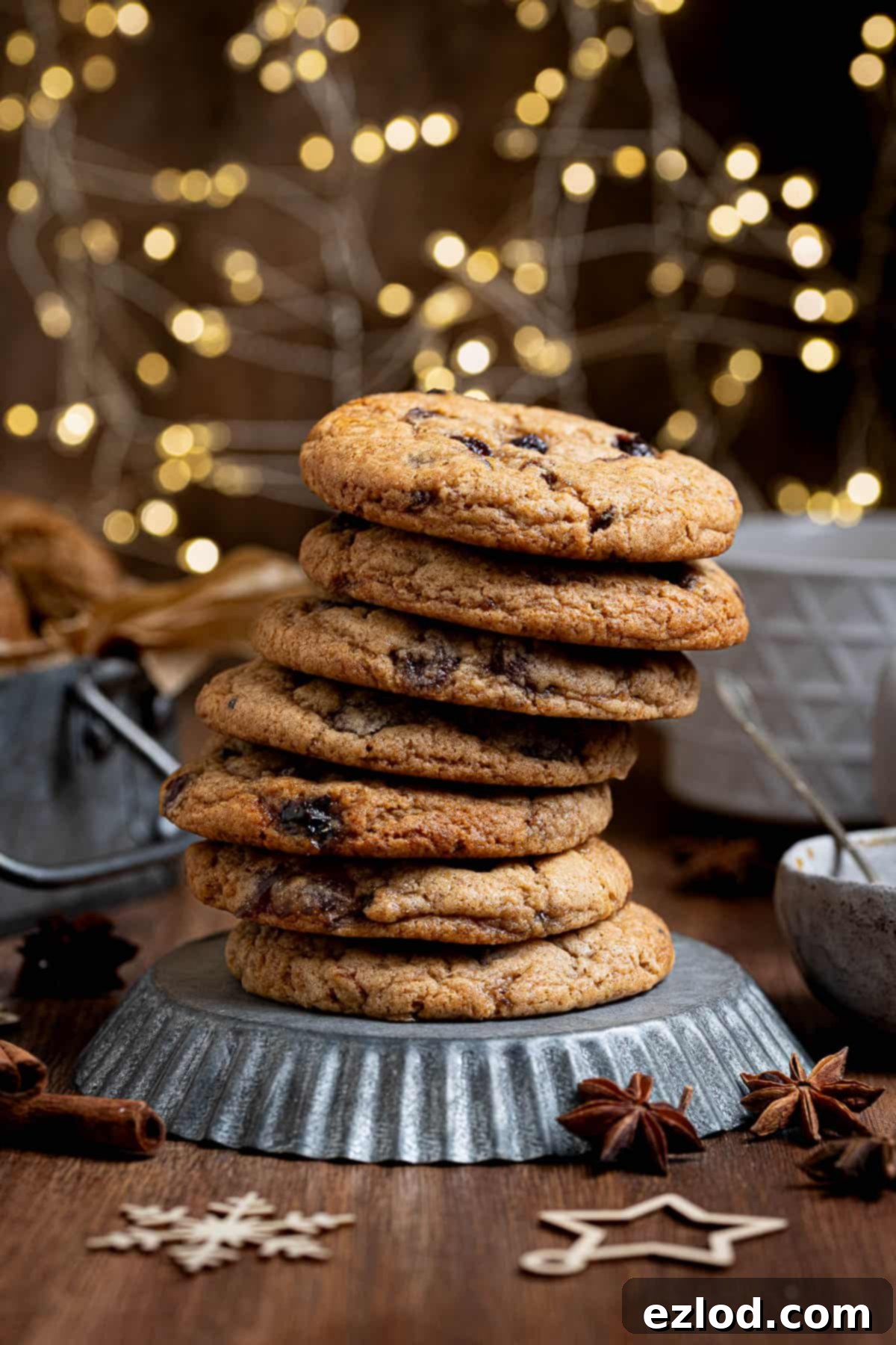 A stack of mincemeat cookies on a metal plate with Christmas lights in the background.