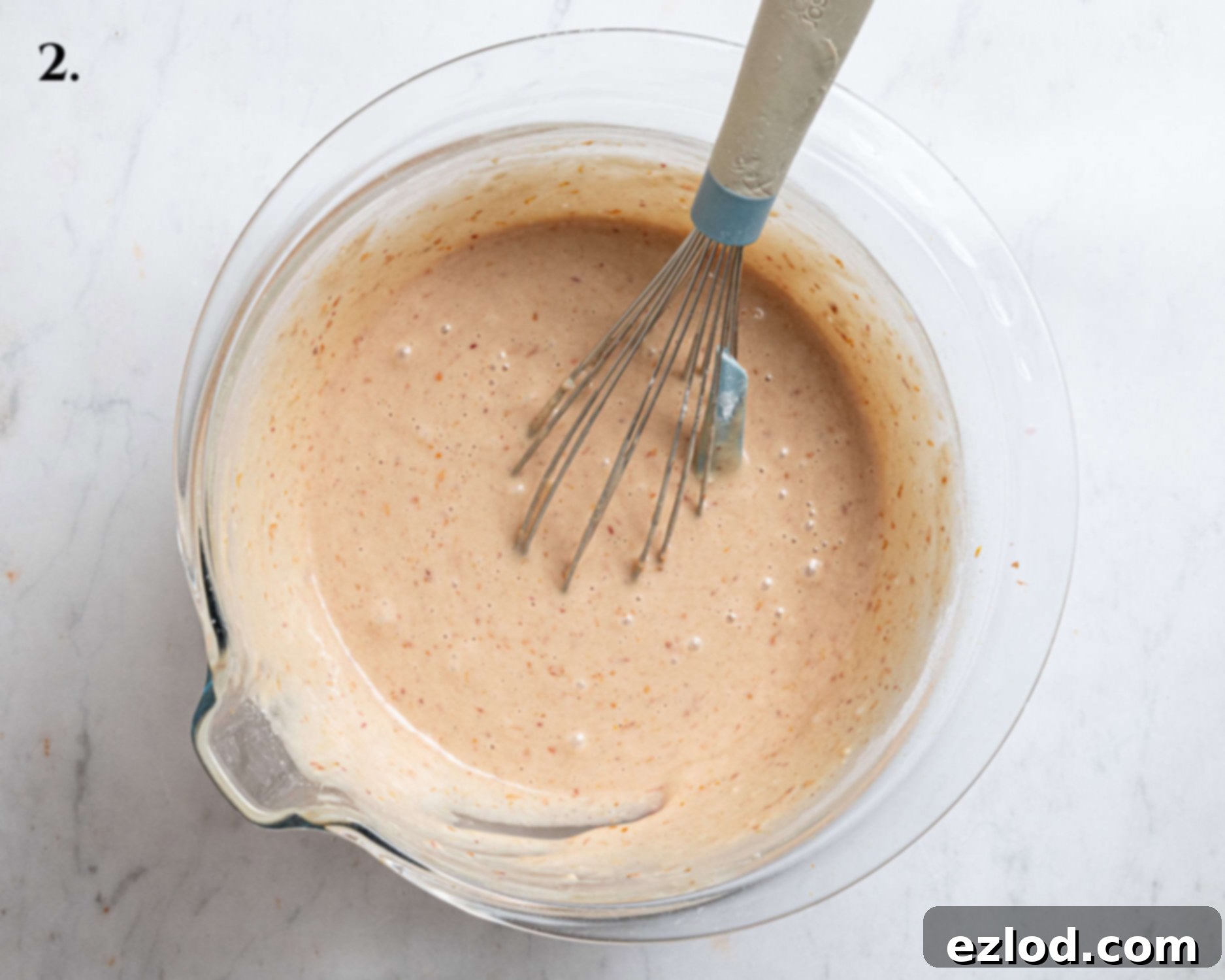 Whisking dry ingredients into the wet ingredients.