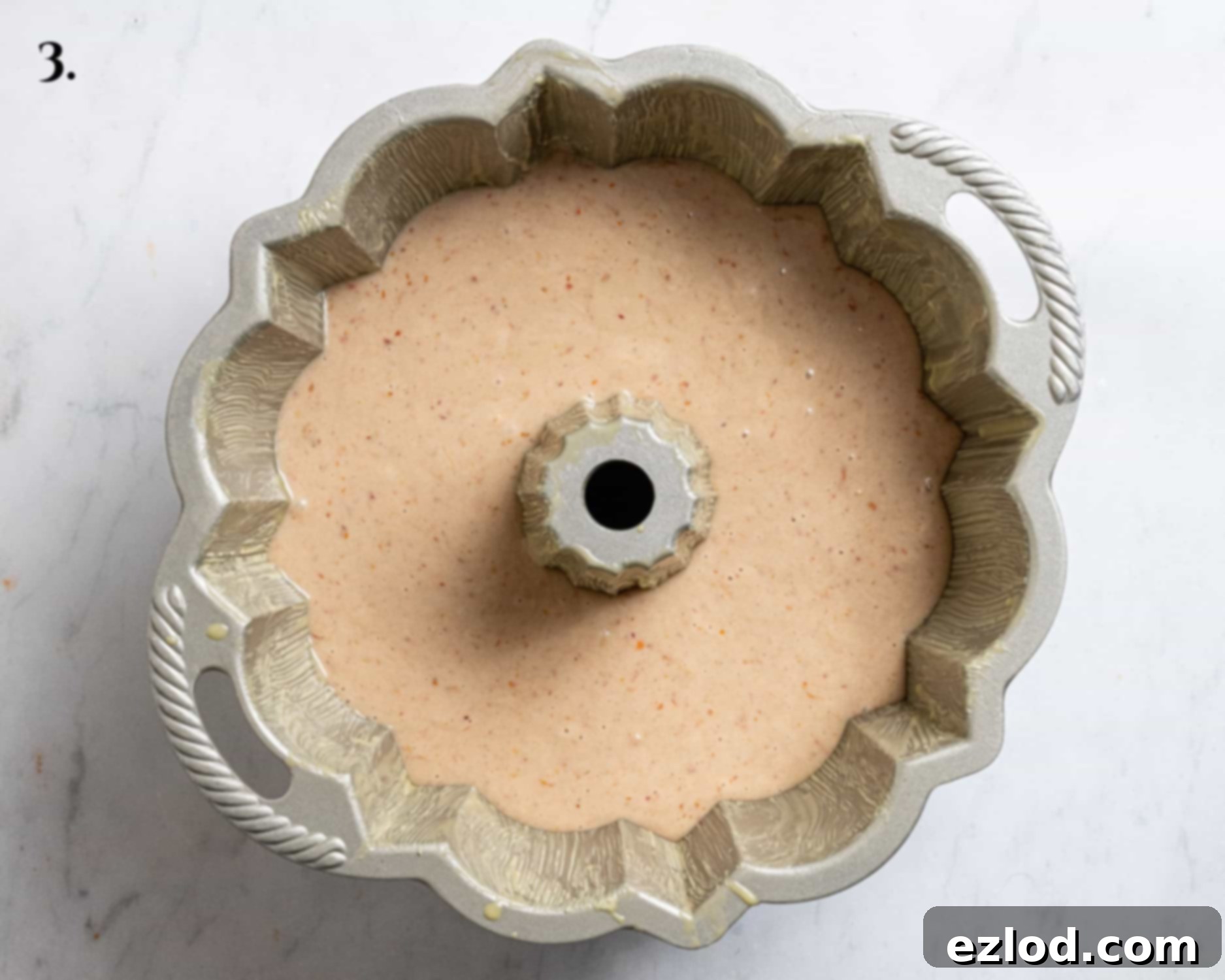 Pouring batter into a greased bundt pan.