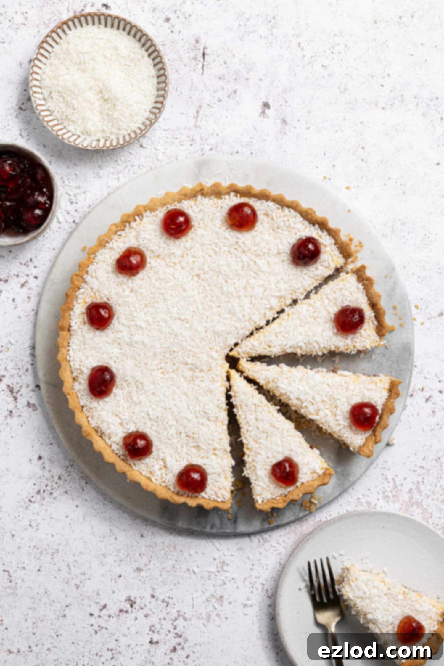 Sliced vegan Manchester tart with coconut and glace cherries